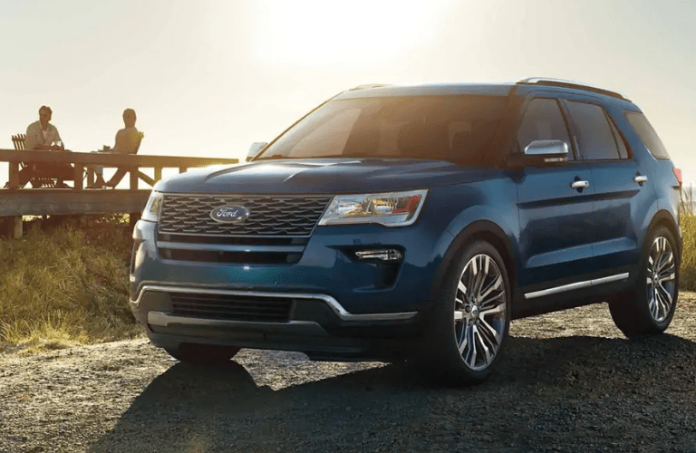 Two people sitting at table and looking at blue 2019 Ford Explorer Platinum
