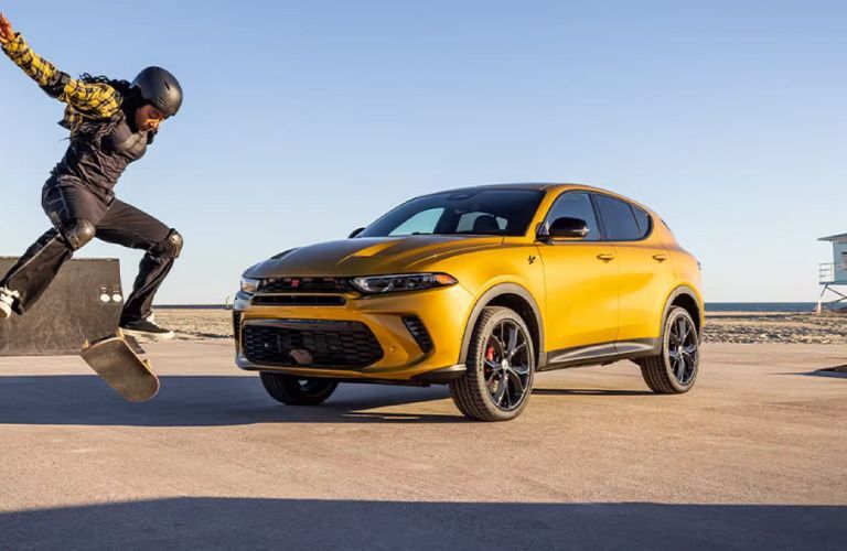2024 Dodge Hornet parked off-road near a skateboarder