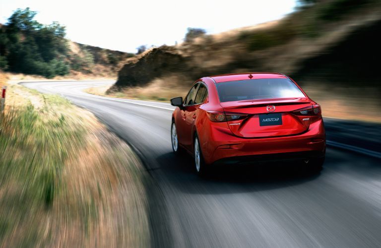 Rear view of the 2014 Mazda3 speeding on the road