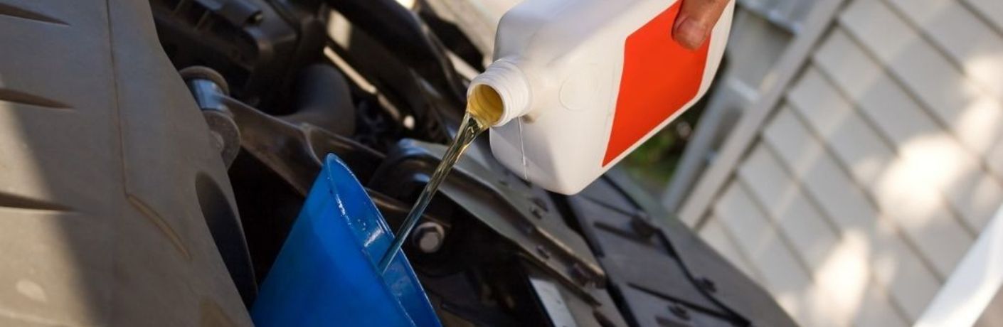 fresh oil being poured in a car