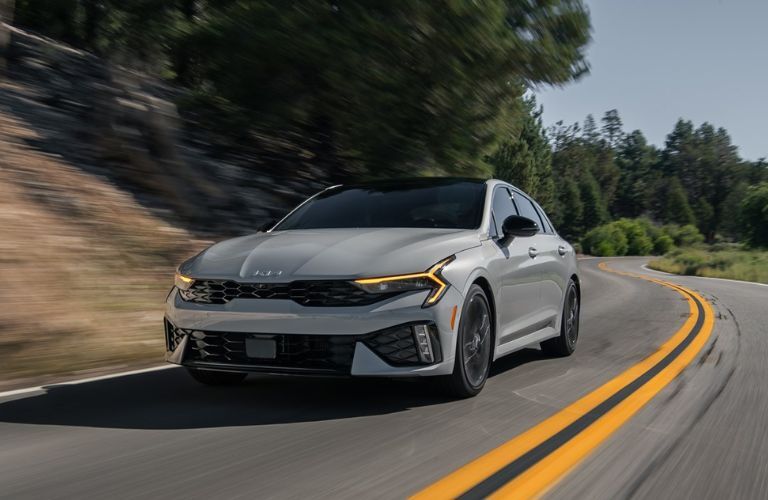 2025 Kia K5 exterior front view driving on the road