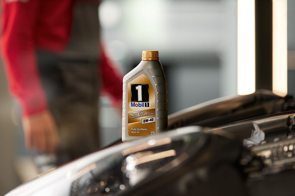 A mechanic pouring engine oil