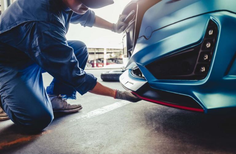 a technician checking under a McLaren