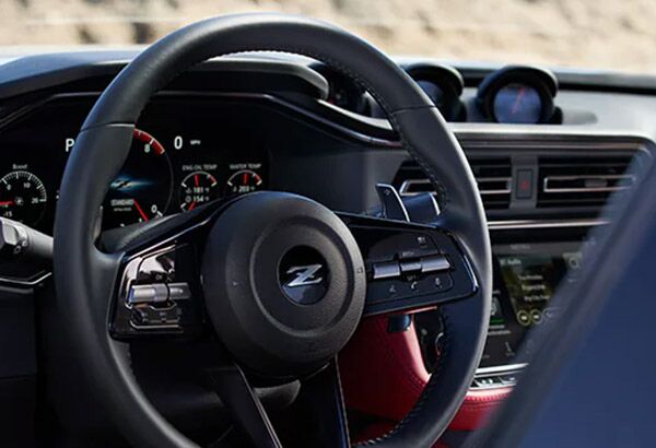 2023 Nissan Z view of cockpit with steering wheel, dashboard, gauge cluster, and touch-screen.