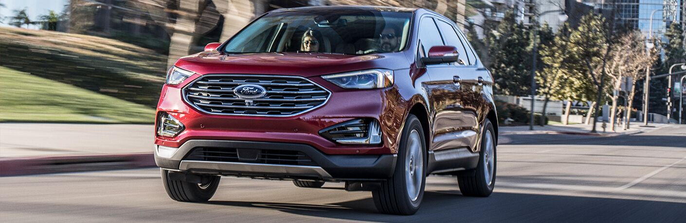 Front view of red 2019 Ford Edge SEL driving down residential road