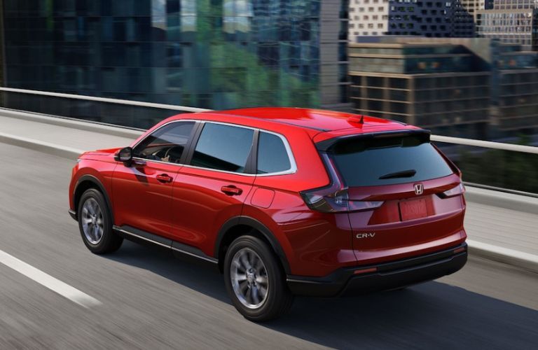 One red color 2023 Honda CR-V is running on the road.