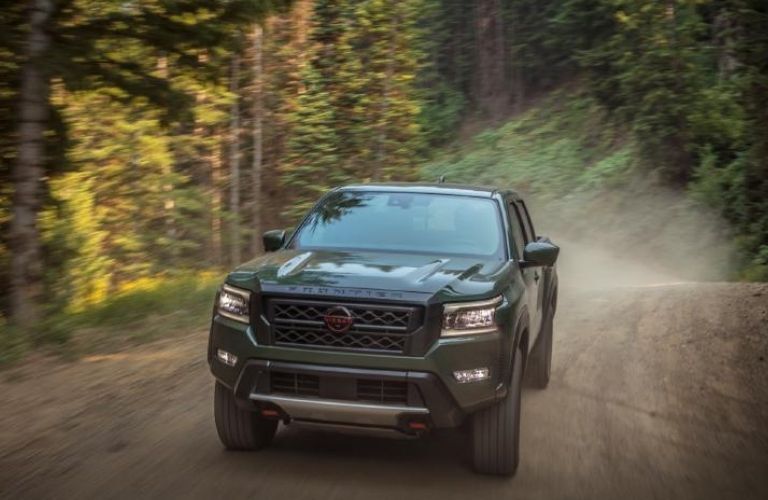 A 2021 Nissan Frontier speeding on a sandy terrain
