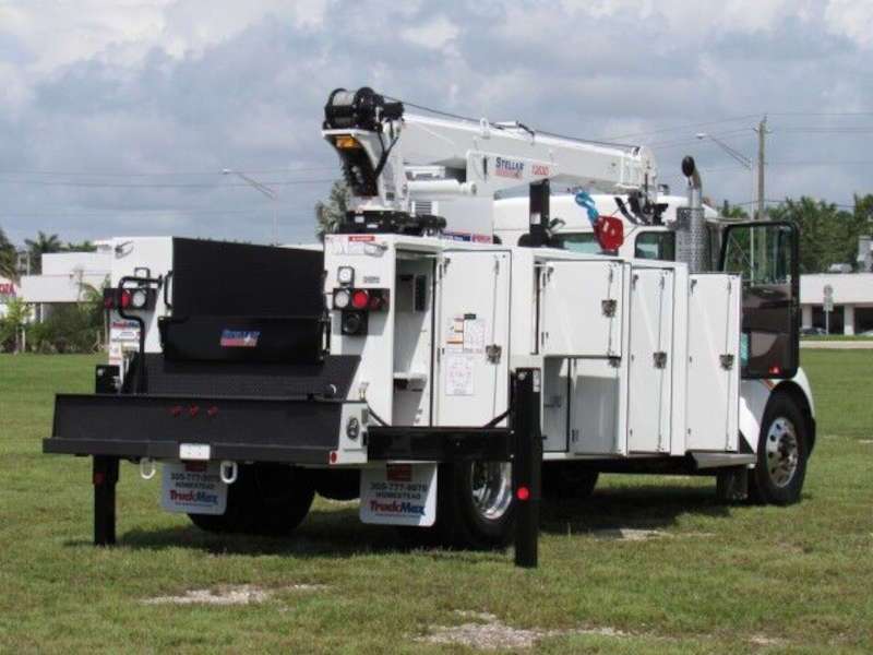 A rear quarter view of a Kenworth picker truck