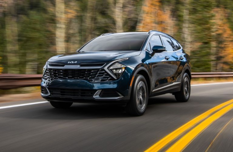 A 2023 Kia Sportage Hybrid taking a turn on a road