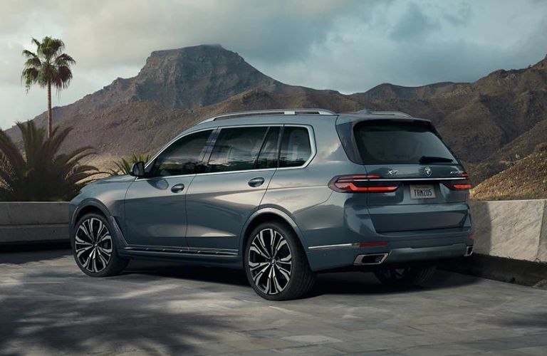 Rear side view of a gray 2022 BMW X7 parked outdoors.