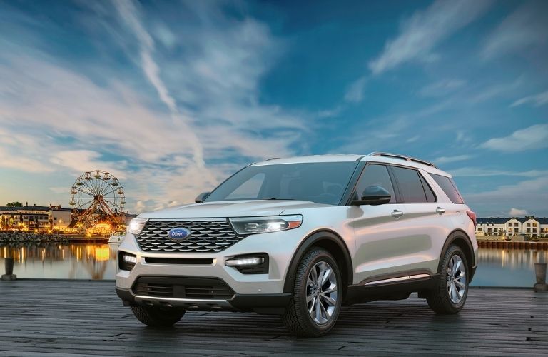 A 2022 Ford Explorer backdropped by a ferris wheel and a city festival