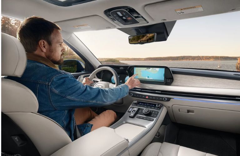 Man sitting at the steering wheel of the 2024 Hyundai Palisade and dashboard view shown