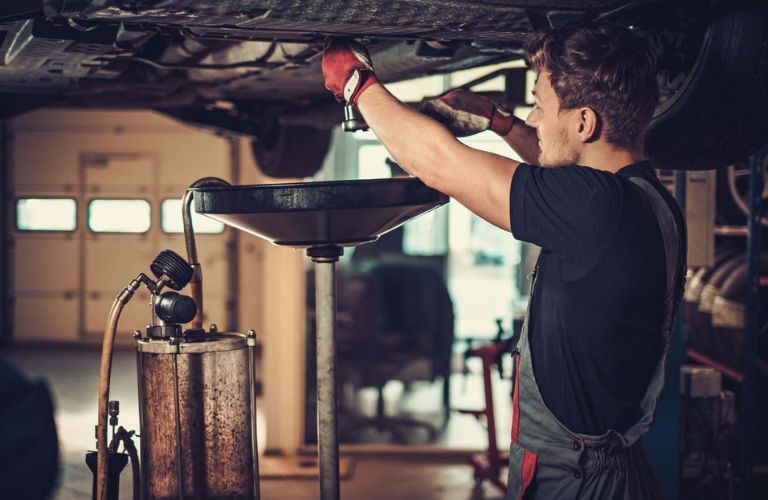 A service person changing a car's oil
