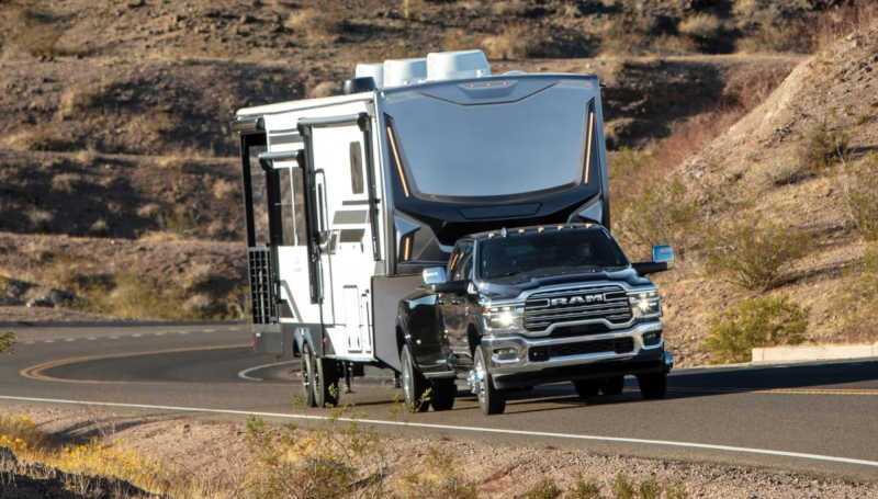 A front 3/4 view of the 2026 Ram 3500 towing a very large camper trailer