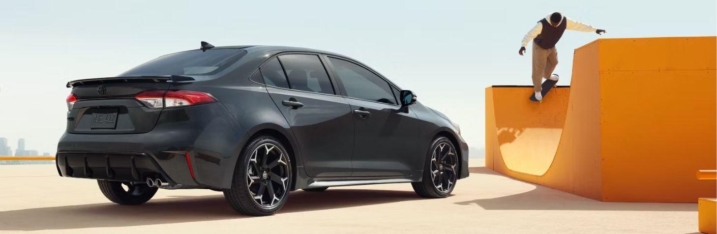 rear quarter view of the 2025 Toyota Corolla FX with a skater in the background