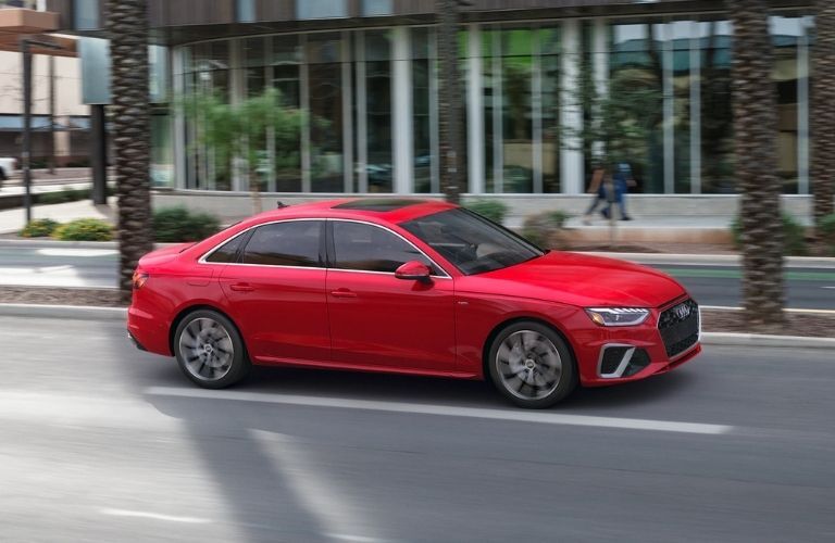 a red Audi sedan on a city road
