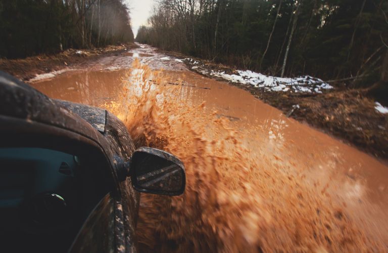 a car off-roading in muddy water