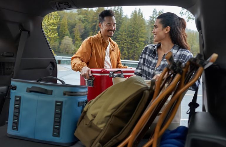 A couple placing their picnic items in the cargo space of the 2024 Toyota Grand Highlander