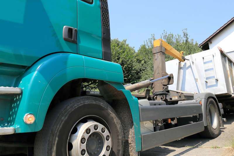 A roll-off truck unloading a container