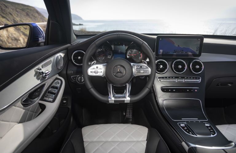 2020 MB GLC Coupe interior front cabin steering wheel dashboard and touchscreen display in front of lake