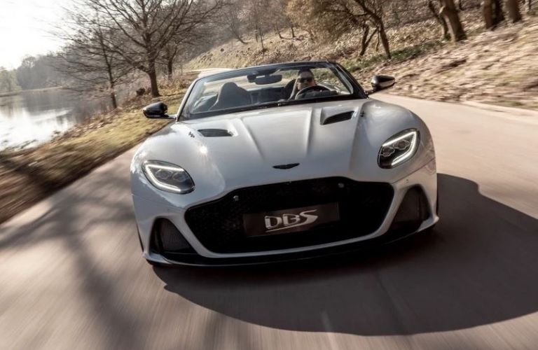 Front view of a gray 2022 Aston Martin DBS driving on a road