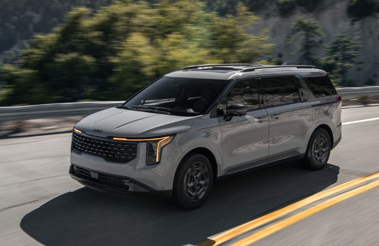 diagonal front view image of the 2025 Kia Carnival MPV on a road