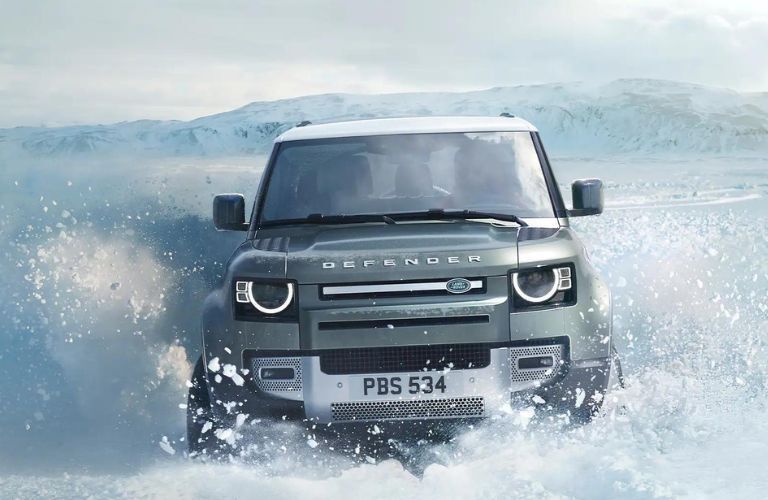 Land Rover Defender driving on snowy road