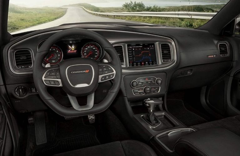 Showing front row black leathered seats with interior dashboard of used Dodge Charger
