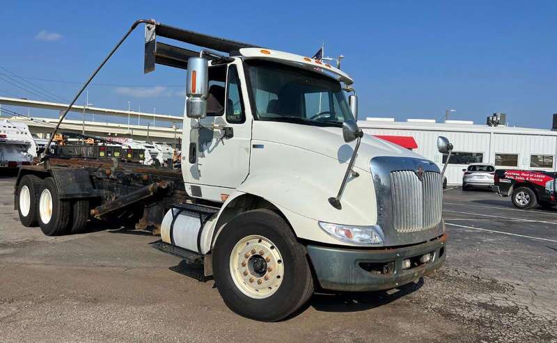 A front quarter view of a used roll off truck for sale at Dirt Cheap Truck Sales.