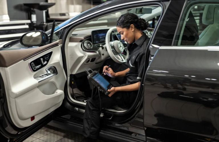 a technician inspecting a Mercedes-Benz