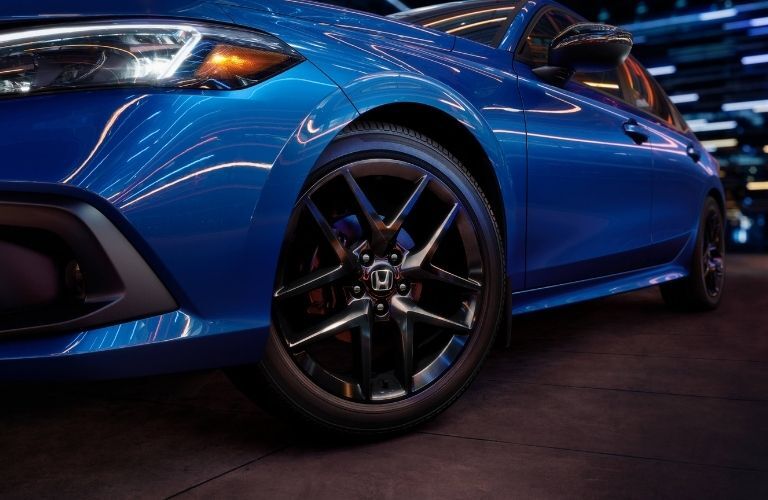 Worms eye view showing the alloy wheels and LED headlights of  a blue-colored 2022 Honda Civic Sedan