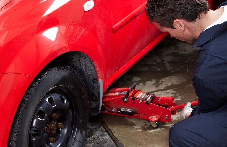A service person repairing car tires