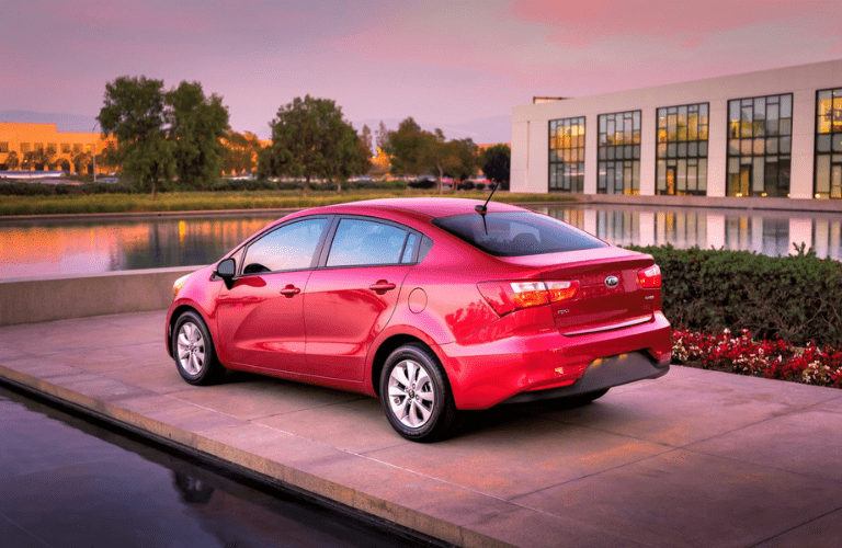 2016 Kia Rio  parked in front of a lake and building