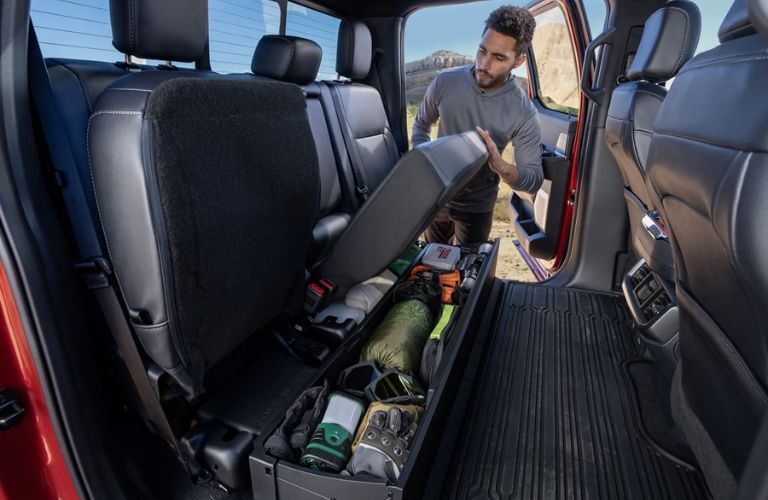 a man using the lockable storage space in the 2025 Ford F-150