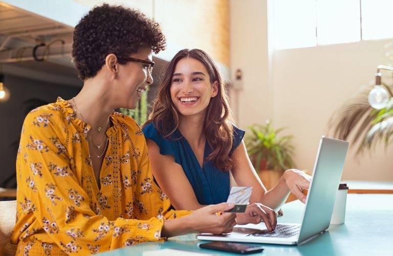 two women using laptop