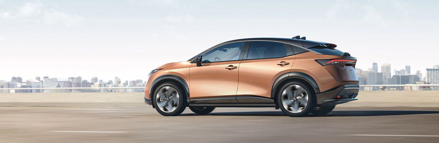 One brown color 2023 Nissan Ariya is running on the road.