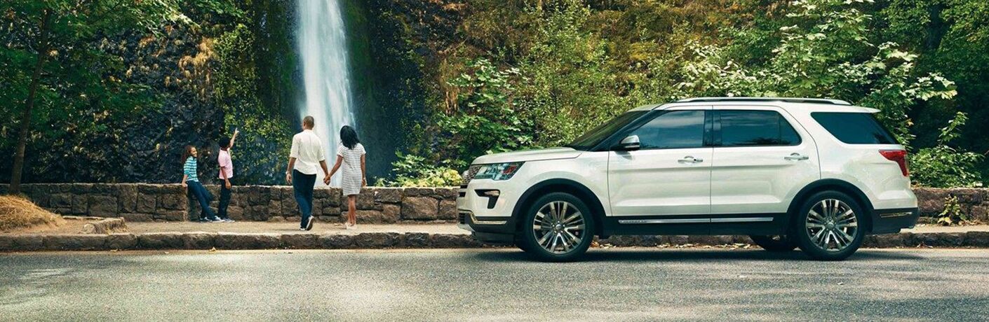 Profile view of white 2019 Ford Explorer parked at waterfall