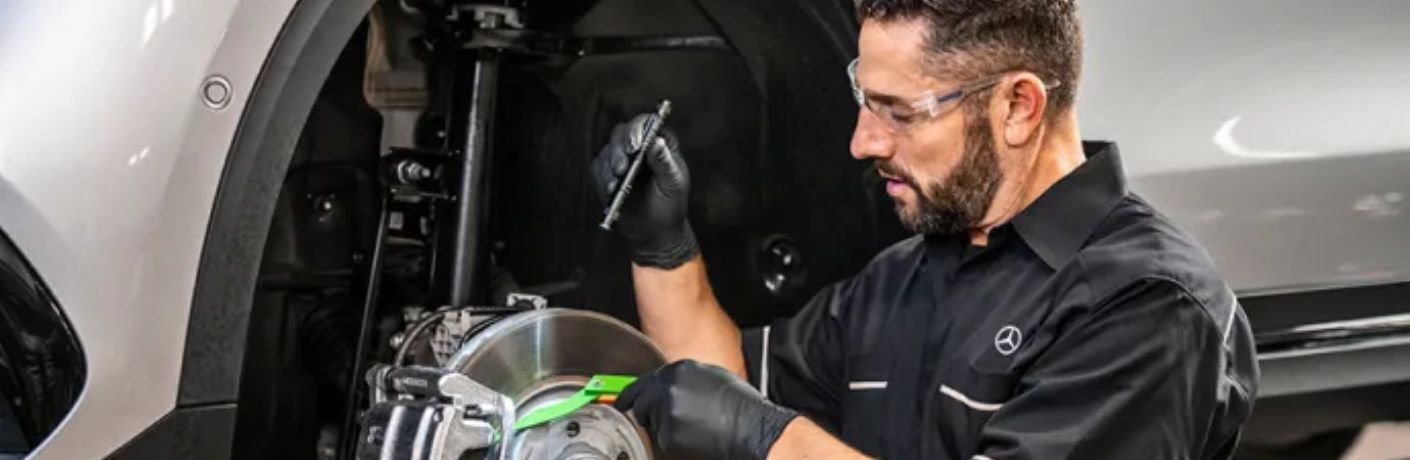A mechanic working on a Mercedes-Benz vehicle