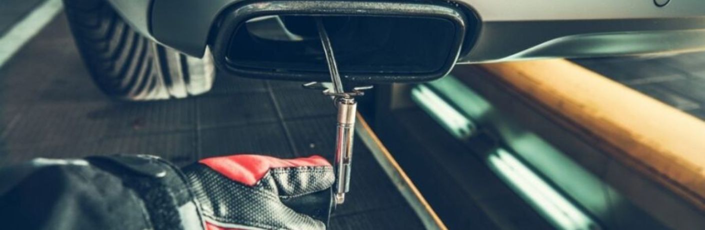 a mechanic working on a Mercedes-Benz muffler