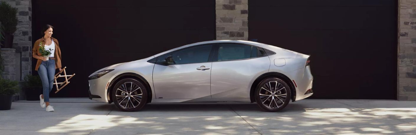 One grey color 2022 Toyota Prius is parked in front of a house.
