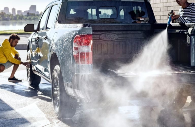 Two men water spraying the 2024 Ford Maverick