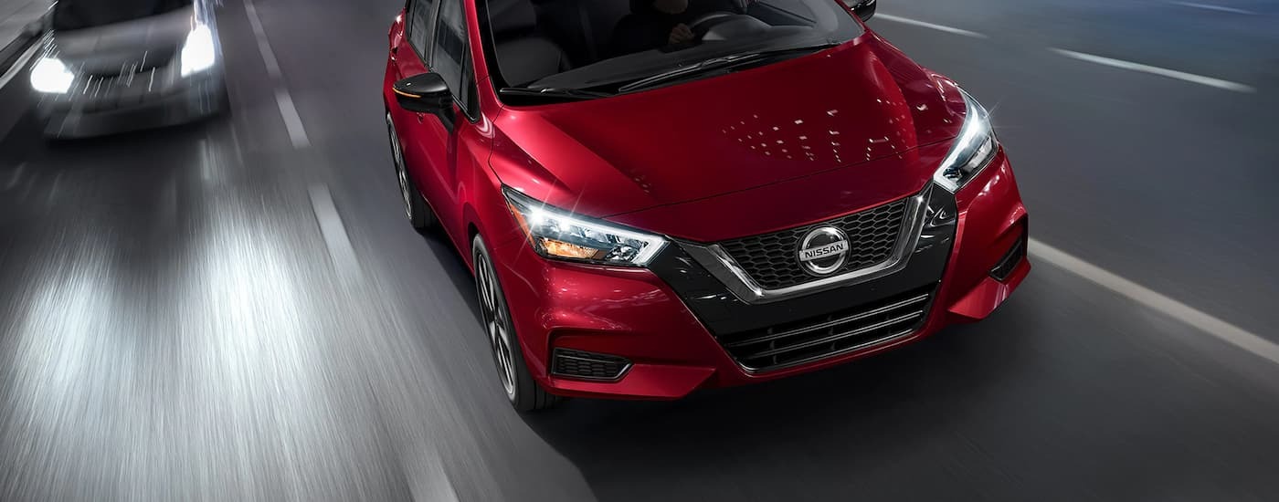 Red 2023 Nissan Versa driving on a highway