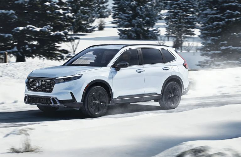 Side view of the 2024 Honda CR-V Hybrid on a snowy road