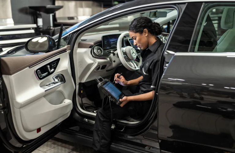woman undertaking a 165+ point inspection for a Mercedes-Benz vehicle