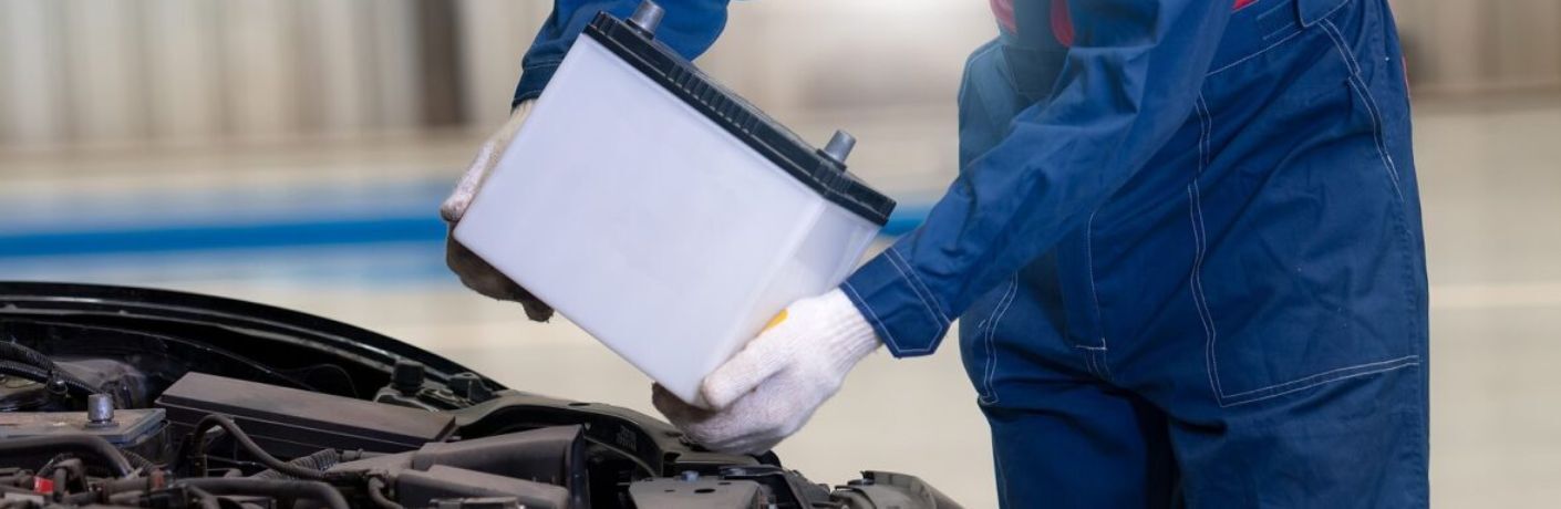 Technician changing the battery of a car