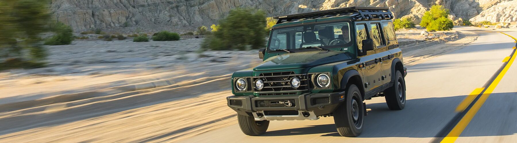 The 2025 INEOS Grenadier driving on desert road.