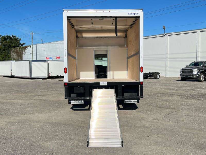 A rear exterior view of a box truck with its ramp down
