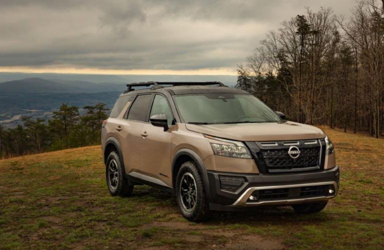 A 2023 Nissan Pathfinder Rock Creek models on a grassy hill
