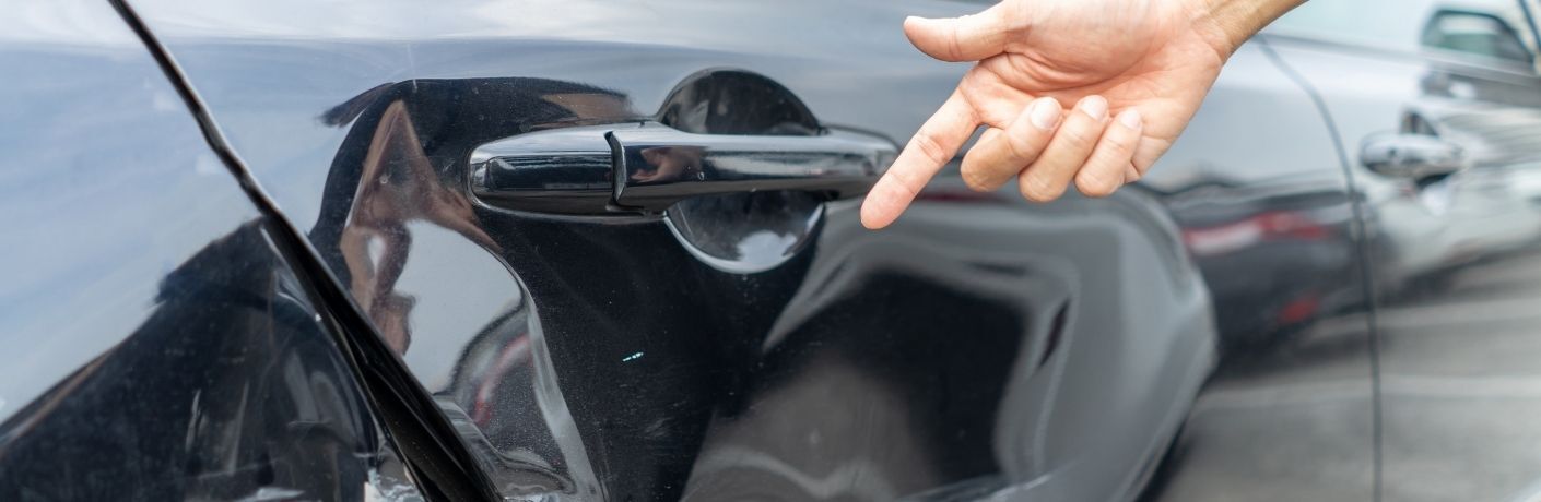 Damaged vehicle being fixed by two workers