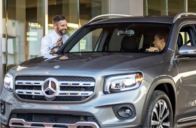 A man talking to man inside a car